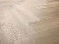 Drewniana podłoga ułożona w jodełkę. Jasne panele tworzą elegancki wzór, który sprawia, że wnętrze wydaje się przestronniejsze.