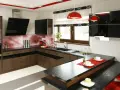 Nowoczesna kuchnia z wyspą zamiast stołu. Ciemne blaty, drewniane fronty, czerwone akcenty i błyszczące dodatki.