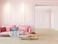 Elegancka różowa kanapa i stoliki kawowe na tle subtelnej sztukaterii ściennej. Inspiracje dla Twojego wnętrza.