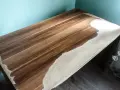 Drewniany blat w trakcie renowacji. Widoczne fragmenty z piaskowanym wykończeniem i naturalnym usłojeniem drewna.