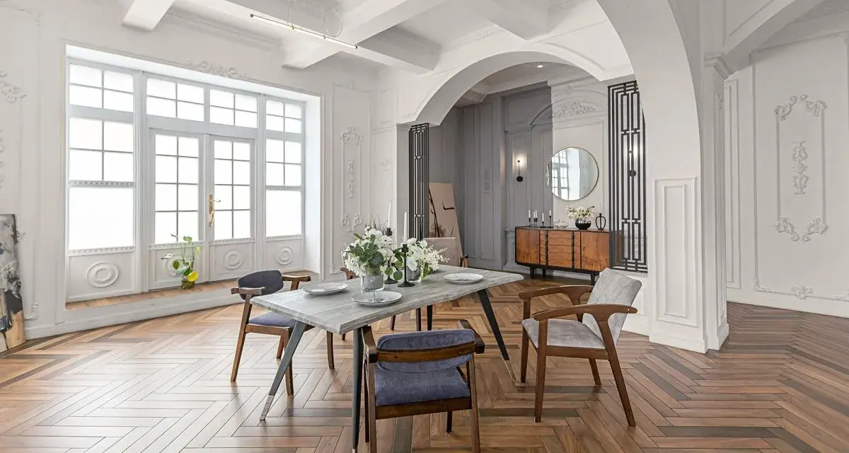 Elegancki salon z jadalnią, łuk wykończony sztukaterią, drewniana podłoga w jodełkę.