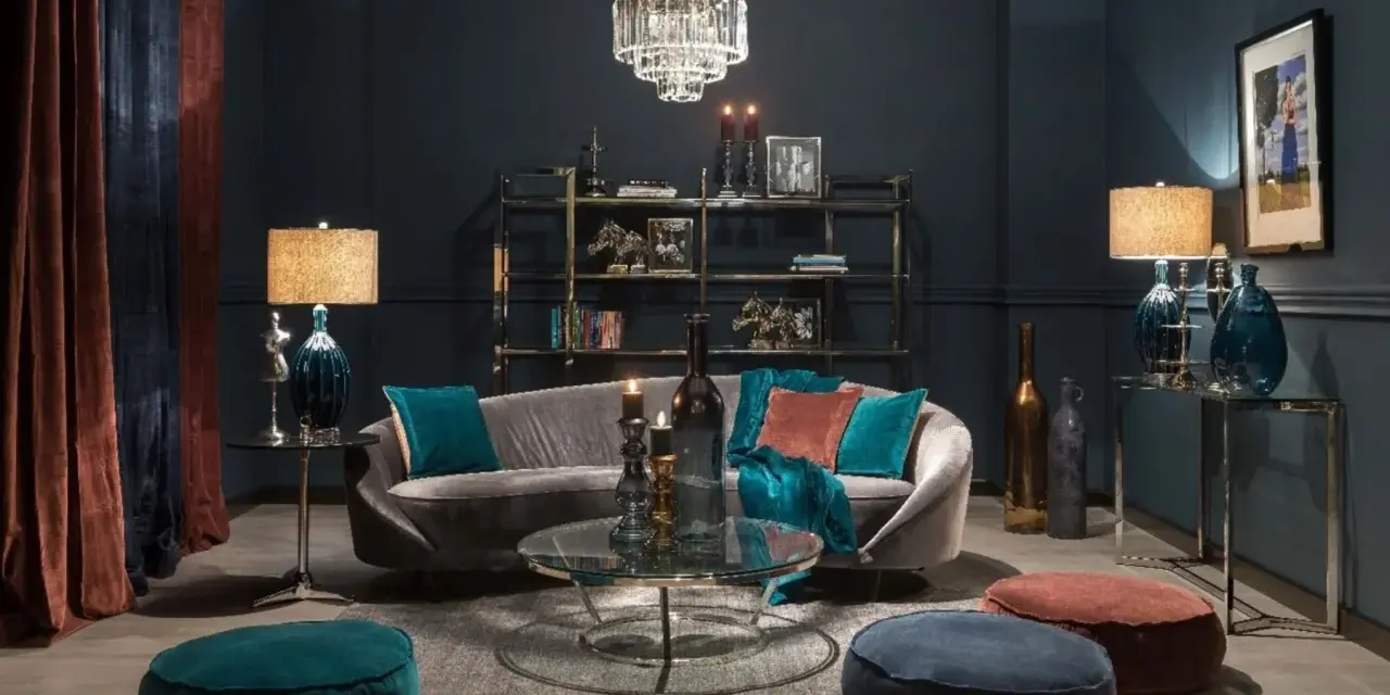 Elegancki salon w odcieniach ciemnego granatu. Miękka sofa, kryształowy żyrandol i aksamitne zasłony tworzą przytulną atmosferę.