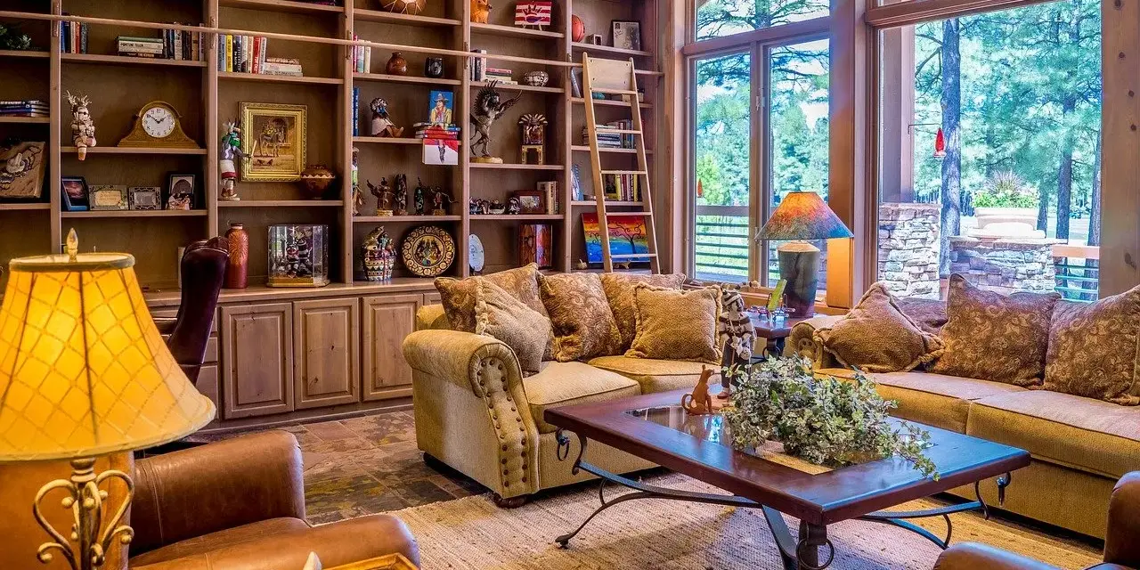 Salon w stylu retro inspiracje: przytulne meble, regały pełne bibelotów i ciepłe światło lampy tworzą atmosferę minionych lat.