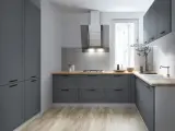 Nowoczesna kuchnia z szarymi frontami i drewnianym blatem. Zastanawiasz się, ile powinien wystawać blat kuchenny? Tutaj widać go na równi z frontami.
