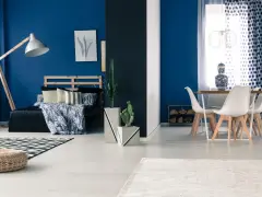 Granatowy salon inspiracje: sypialnia z łóżkiem i stolik z krzesłami.