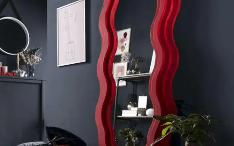 Oryginalna rama do lustra w kształcie fali, czerwona, dodaje stylu. Zobacz, jak zrobić ramę do lustra DIY.