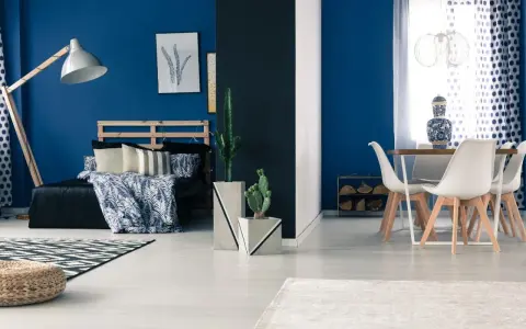 Granatowy salon inspiracje: sypialnia z łóżkiem i stolik z krzesłami.