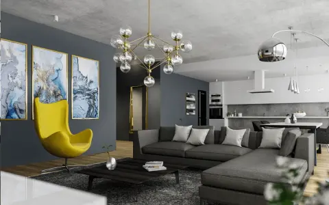 Nowoczesny salon z szarą kanapą i żółtym fotelem. Obrazy i designerska lampa dodają charakteru, pokazując, jak rozjaśnić pokój dodatkami.