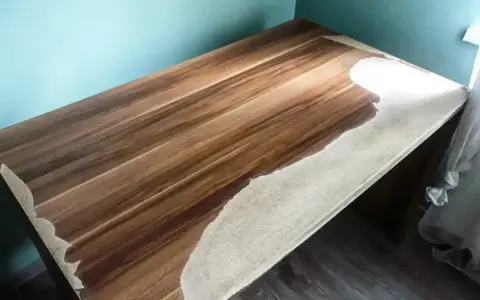 Drewniany blat w trakcie renowacji. Widoczne fragmenty z piaskowanym wykończeniem i naturalnym usłojeniem drewna.