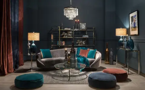 Elegancki salon w odcieniach ciemnego granatu. Miękka sofa, kryształowy żyrandol i aksamitne zasłony tworzą przytulną atmosferę.