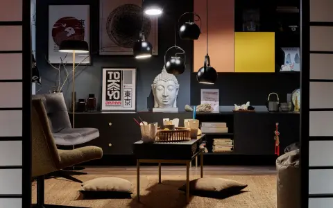 Salon w stylu eklektycznym z motywami azjatyckimi. Wygodne fotele, stolik z poduszkami, rzeźba Buddy i plakaty z Japonii tworzą przytulną atmosferę.
