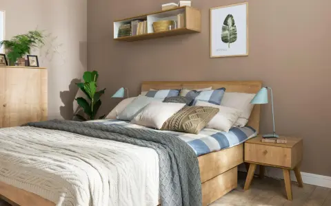 Inspiracja, jak udekorować łóżko w sypialni: drewniane meble, pastelowe poduszki, plecione koce i zielone rośliny tworzą przytulną atmosferę.
