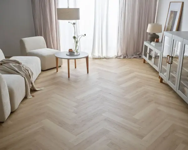 Jasna podłoga w jodełkę w salonie, z beżową kanapą i fotelami, tworzy przytulną atmosferę.