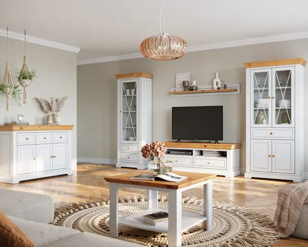 Przytulny salon styl klasyczny z białymi meblami i drewnianymi blatami. W centrum stolik kawowy, obok komoda i dwie witryny.