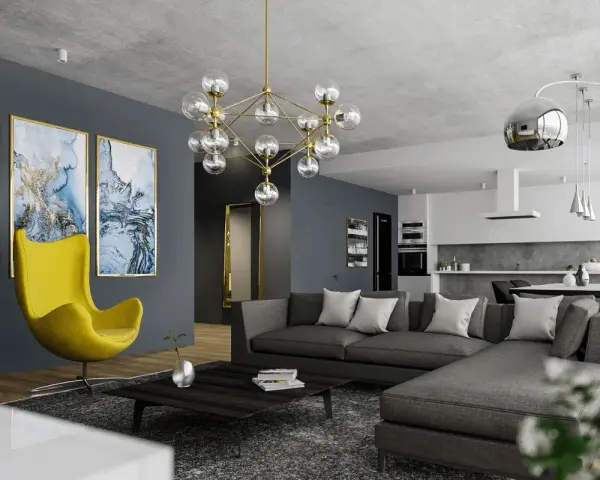 Nowoczesny salon z szarą kanapą i żółtym fotelem. Obrazy i designerska lampa dodają charakteru, pokazując, jak rozjaśnić pokój dodatkami.