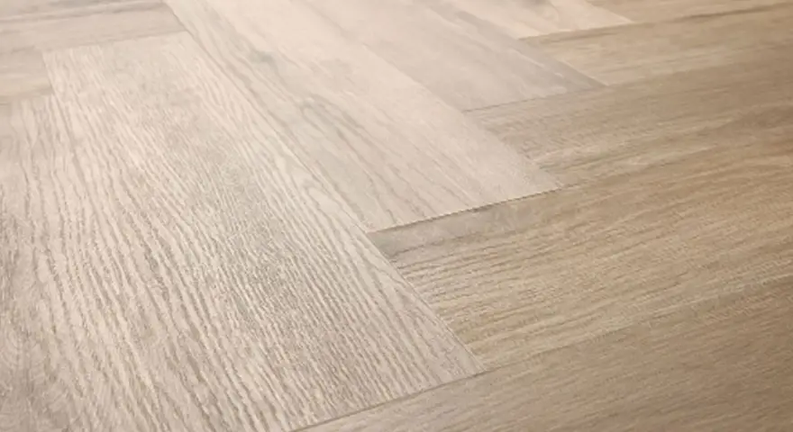 Drewniana podłoga ułożona w jodełkę. Jasne panele tworzą elegancki wzór, który sprawia, że wnętrze wydaje się przestronniejsze.