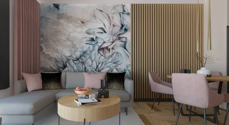 Elegancki salon z sofą i stolikiem kawowym w odcieniach brązu i pudrowego różu. Na ścianie duża, malarska tapeta z kwiatowym motywem.