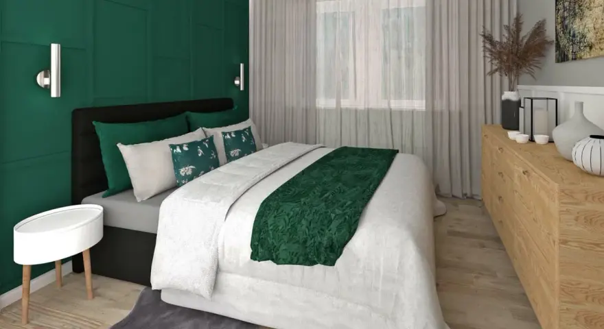 Elegancka sypialnia w butelkowej zieleni i szarości. Ściana za łóżkiem w głębokim odcieniu zieleni, z geometrycznymi panelami. Pościel biała, z zielonym akcentem.