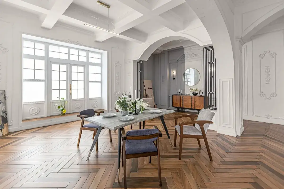 Elegancki salon z jadalnią, gdzie łuk wykończono sztukaterią, tworząc stylowe przejście.