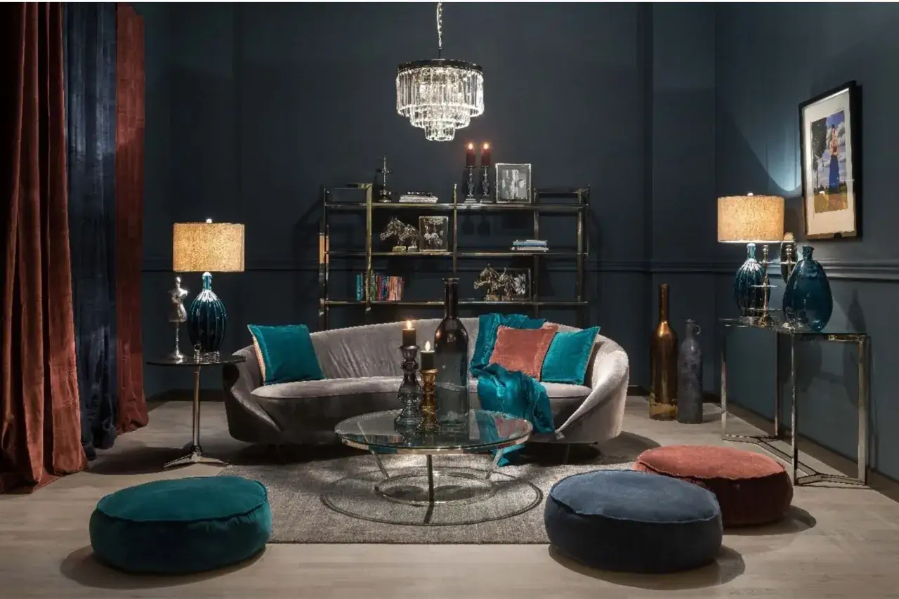 Elegancki salon w odcieniach ciemnego granatu. Miękka sofa, kryształowy żyrandol i aksamitne zasłony tworzą przytulną atmosferę.